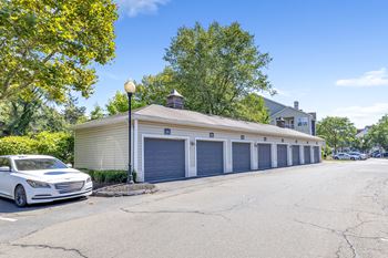 A white car is parked in front of a garage.